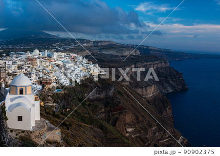 ギリシャ　サントリーニ島の断崖の上にあるフィラの街並みと聖スティリアノスのカトリック教会 90902375