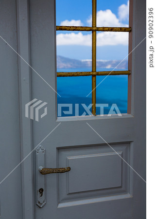 ギリシャ　サントリーニ島のフィラ　扉の向こうに広がるコバルトブルーの海 90902396