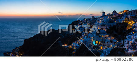 ギリシャ　サントリーニ島のイアのイア・キャッスルから見える夕暮れ時の街並みと風車 90902580