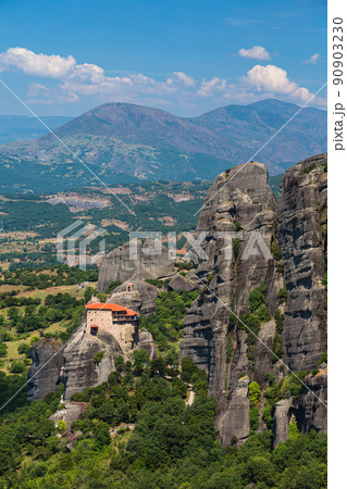 ギリシャ メテオラの断崖絶壁の岩山の上に建つ聖ニコラオス・アナパフサス修道院と後ろに広がる山 ギリシャ メテオラの断崖絶壁の岩山の上に建つ聖ニコラオス・アナパフサス修道院と後ろに広がる山 90903230