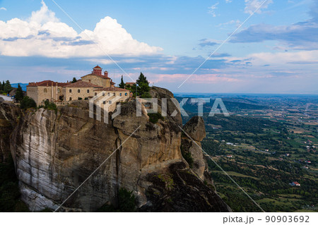 ギリシャ　メテオラの断崖絶壁の岩山の上に建つ聖ステファノス修道院と奇岩群とカランバカの街並み. 90903692