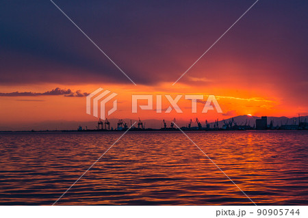 ギリシャ 夕焼けでオレンジに染まった空とテッサロニキから見えるテルメ湾とテッサロニキ港 ギリシャ 夕焼けでオレンジに染まった空とテッサロニキから見えるテルメ湾とテッサロニキ港 90905744