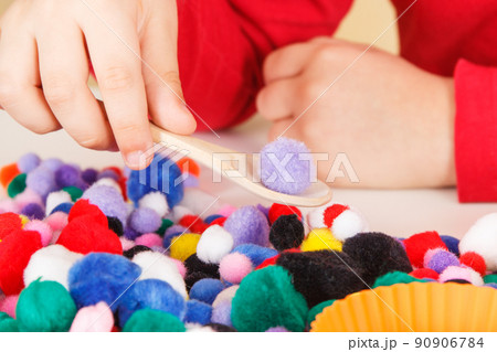 Little baby boy playing with small pompoms, wooden spoon and cups. Development of kids motor skills Little baby boy playing with small pompoms, wooden spoon and cups. Development of kids motor skills 90906784