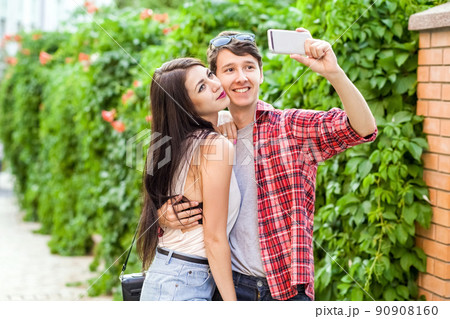 Happy beautiful couple taking a selfie on a mobile phone. huging and have a fun together. 90908160
