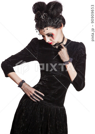 Young beautiful gothic woman with white skin and red lips with bloody drops wearing black collar with spikes. Red smokey eyes. Halloween makeup. Young beautiful gothic woman with white skin and red lips with bloody drops wearing black collar with spikes. Red smokey eyes. Halloween makeup. 90909653