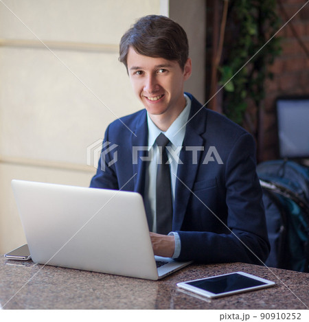 young man in business suit sitting in office and working young man in business suit sitting in office and working 90910252