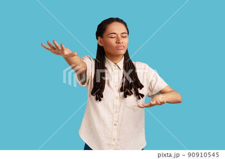 Portrait of blind woman with outstretched hands walking alone with closed eyes in darkness, feeling disoriented confused, lost road, wearing white shirt. Indoor studio shot isolated on blue background Portrait of blind woman with outstretched hands walking alone with closed eyes in darkness, feeling disoriented confused, lost road, wearing white shirt. Indoor studio shot isolated on blue background 90910545