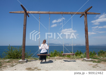 Woman on a swing on summer day Woman on a swing on summer day 90912462