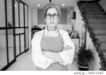 Portrait of strict granny standing in displeased pose staring angry at camera Portrait of strict granny standing in displeased pose staring angry at camera 90913385