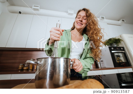 Young woman is preparing food in the kitchen. Prepare Food. Young woman is preparing food in the kitchen. Prepare Food. 90913587