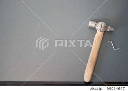 On the details of chipboard furniture there is a hammer and a hex key, top view. 90914647