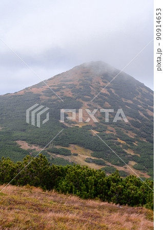 The top of the mountain in the fog, and the foot of the mountain illuminates the sun, the weather in the mountains. The top of the mountain in the fog, and the foot of the mountain illuminates the sun, the weather in the mountains. 90914653