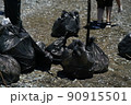 bags of collected garbage from the beach for recycling, cleaning the beach from pollution 90915501