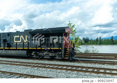 British Columbia, Canada - April 30 2021 : Canadian National Railway freight train traveling on rural area. 90923047
