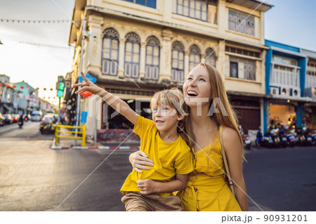 Mom and son tourists on the Street in the Portugese style Romani in Phuket Town. Also called Chinatown or the old town. Traveling with kids concept Mom and son tourists on the Street in the Portugese style Romani in Phuket Town. Also called Chinatown or the old town. Traveling with kids concept 90931201