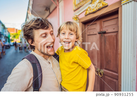 Dad and son tourists on the Street in the Portugese style Romani in Phuket Town. Also called Chinatown or the old town. Traveling with kids concept Dad and son tourists on the Street in the Portugese style Romani in Phuket Town. Also called Chinatown or the old town. Traveling with kids concept 90931255