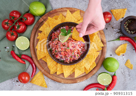 freshly made salsa dip sauce with nacho chips on wooden board 90931315