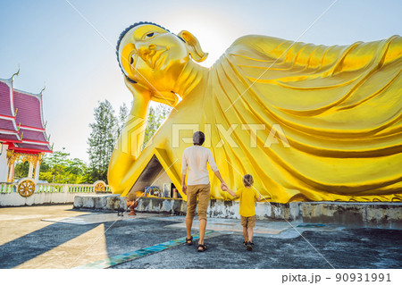 Happy tourists dad and son on background ofLying Buddha statue Happy tourists dad and son on background ofLying Buddha statue 90931991