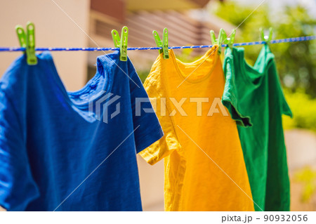 Multicolor shirts on clothesline in sunny day 90932056
