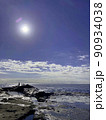 岩場の海と青い空と輝く太陽 90934038