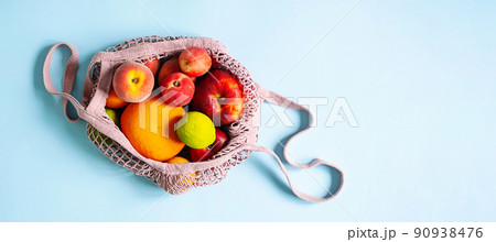 String mesh bag for grocery with various fruits. Reusable shopping tote bag, zero waste concept. String mesh bag for grocery with various fruits. Reusable shopping tote bag, zero waste concept. 90938476