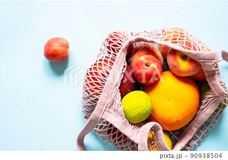 String mesh bag for grocery with various fruits. Reusable shopping tote bag, zero waste concept. String mesh bag for grocery with various fruits. Reusable shopping tote bag, zero waste concept. 90938504