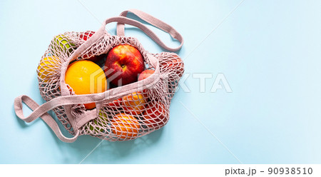 String mesh bag for grocery with various fruits. Reusable shopping tote bag, zero waste concept. String mesh bag for grocery with various fruits. Reusable shopping tote bag, zero waste concept. 90938510
