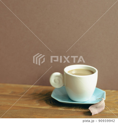 Cup of coffee on wooden table. brown wall background 90939942