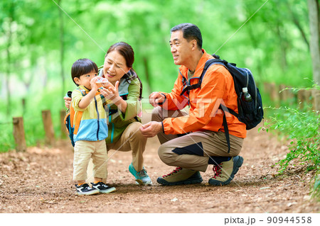 孫と一緒に山歩きするシニア夫婦 90944558