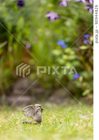 芝生の上に置いてある可愛い素焼のドラゴンの置物 90944826