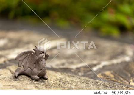 石畳の上に置いてある可愛い素焼のドラゴンの置物 90944988