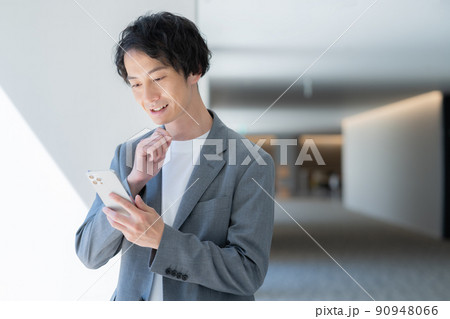 スマホで会話する若いオフィスカジュアルなビジネスマン 撮影協力「LINK FOREST] 90948066