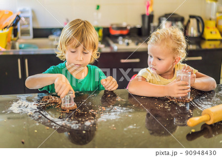 Two children a boy and a girl make cookies from dough Two children a boy and a girl make cookies from dough 90948430