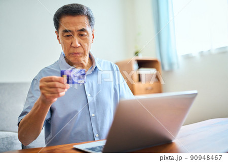 ネットショッピングをするシニア男性 90948467