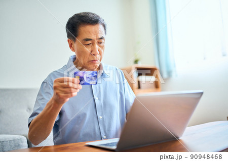 ネットショッピングをするシニア男性 90948468
