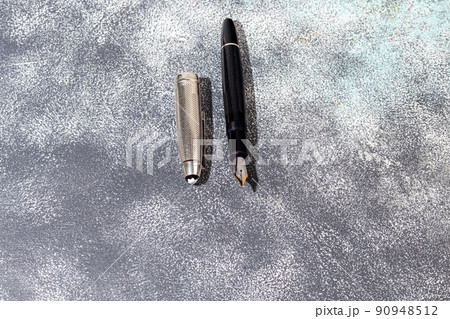 Fountain pen on a marble and gray background. Selective focus. Fountain pen on a marble and gray background. Selective focus. 90948512