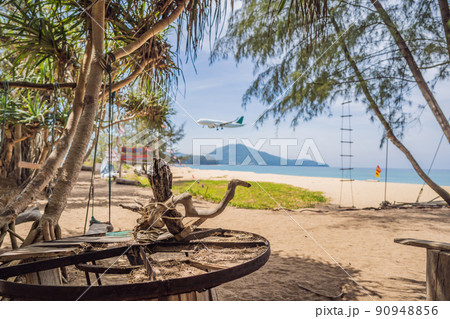 Natural tropical sandy beach and calm sea landscape with trees and blue sky background. Mai Khao beach on Phuket island, Thailand Natural tropical sandy beach and calm sea landscape with trees and blue sky background. Mai Khao beach on Phuket island, Thailand 90948856
