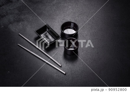 Wooden sushi sticks on a dark concrete background Wooden sushi sticks on a dark concrete background 90952800
