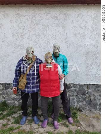 Gas masks. Three people with gas masks and brick wall behind with copy space. Danger of chemical weapon. Gas masks. Three people with gas masks and brick wall behind with copy space. Danger of chemical weapon. 90953055