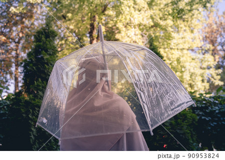 Autumn. Lonely muslim woman in a headscarf under a transparent umbrella with rain drops walking in a park, garden. Rainy day landscape. Vintage Toned Autumn. Lonely muslim woman in a headscarf under a transparent umbrella with rain drops walking in a park, garden. Rainy day landscape. Vintage Toned 90953824