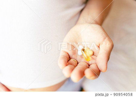 Maternal supplements pill. Happy smiling woman taking pill with supplement vitamin Omega 3. Pregnancy, medicine health care concept. 90954058