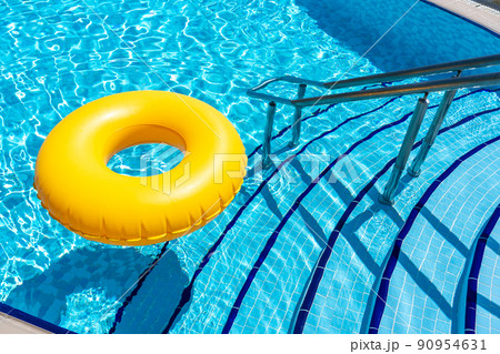 Yellow inflatable ring floating in swimming pool. Vacation concept with copy space 90954631