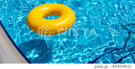 Yellow ring floating in refreshing blue swimming pool 90954632