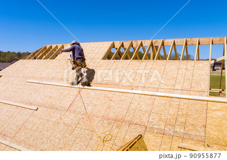 Home roof construction applying roof plywood panels in new house 90955877