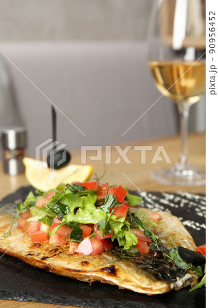 Delicious grilled fish with vegetables served on wooden table. Space for text Delicious grilled fish with vegetables served on wooden table. Space for text 90956452