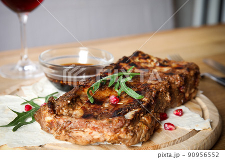 Delicious grilled ribs on wooden board, closeup Delicious grilled ribs on wooden board, closeup 90956552