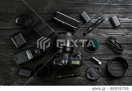 Flat lay composition with equipment for professional photographer on black wooden table Flat lay composition with equipment for professional photographer on black wooden table 90956709