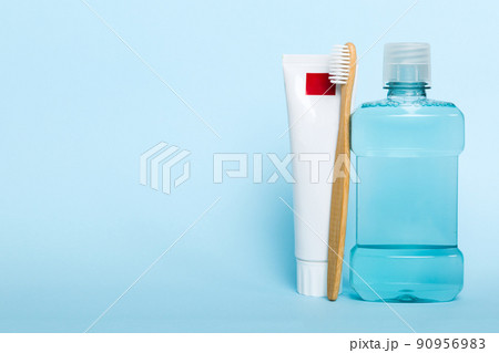 Mouthwash and other oral hygiene products on colored table top view with copy space. Flat lay. Dental hygiene. Oral care products and space for text on light background. concept Mouthwash and other oral hygiene products on colored table top view with copy space. Flat lay. Dental hygiene. Oral care products and space for text on light background. concept 90956983