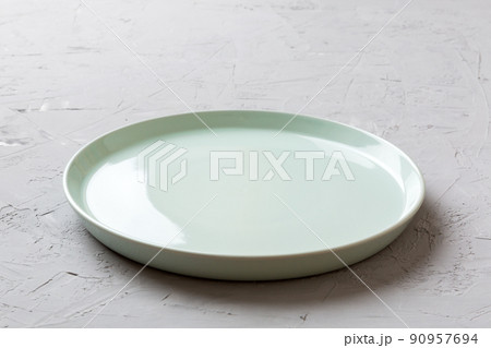 Perspective view of empty blue plate on cement background. Empty space for your design Perspective view of empty blue plate on cement background. Empty space for your design 90957694