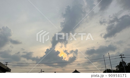 雲の隙間から顔を出す夕方の太陽 90958171